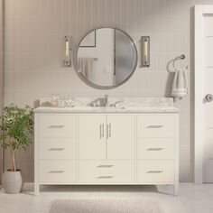 a bathroom with two sinks and a round mirror on the wall next to a potted plant