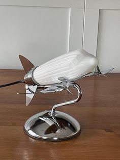 a white bird sculpture sitting on top of a wooden table