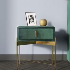 a green sideboard with a gold frame on it next to a painting and a vase