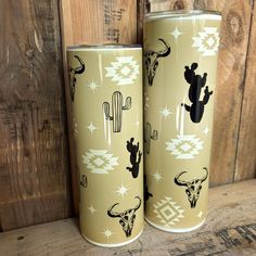 two yellow tumblers with black and white designs on them, sitting next to each other