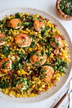 a white plate topped with shrimp and corn