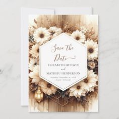 a wedding save the date card with flowers and candles on it, sitting on top of a