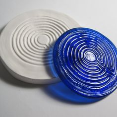 two blue and white frisbees sitting next to each other