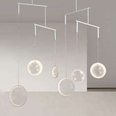 several suspended glass balls are hanging from the ceiling in an empty room with white walls and flooring