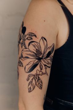 a woman's arm with a flower tattoo on the left side of her arm