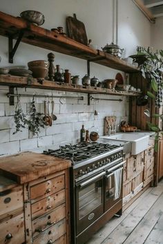 an old fashioned kitchen with wooden cabinets and shelves