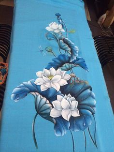 a blue table cloth with white flowers painted on it