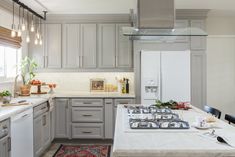 a kitchen with gray cabinets and white counter tops