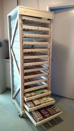 a wooden rack filled with lots of different types of chocolates on top of carpeted flooring