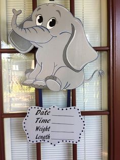 an elephant sign hanging from the side of a window next to a wooden frame with a sign that says, pitte time weight length