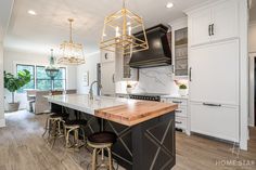 a large kitchen with an island and bar stools