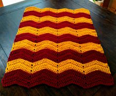 a crocheted blanket sitting on top of a wooden floor