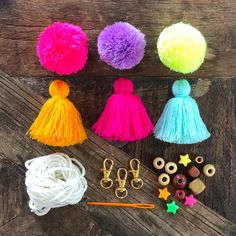 colorful tassels and other craft supplies laid out on a wooden surface