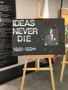 a sign with flowers on it that says ideas never die, and an image of a man in a suit