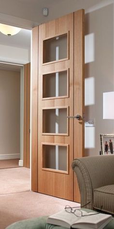 a living room filled with furniture and a book shelf next to a door that has glass shelves on it