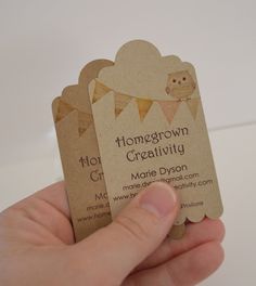 a hand holding two business cards with an owl on one and a bunting banner on the other