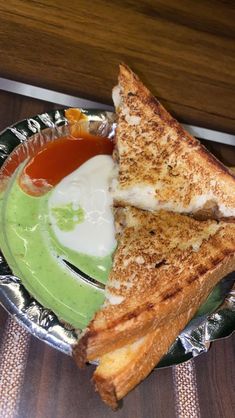 a grilled cheese and guacamole sandwich on a plate with dipping sauce