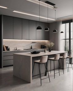 a modern kitchen with an island and bar stools next to the countertop that is illuminated by pendant lights