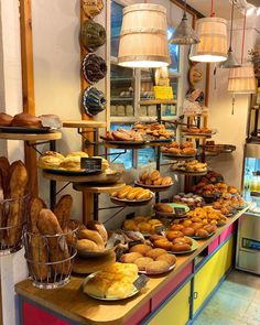 a bakery filled with lots of different types of breads and pastries on display