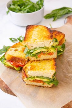 two sandwiches cut in half sitting on top of a cutting board