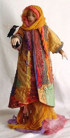 a doll is dressed in colorful clothing and holding a black bird on her arm,