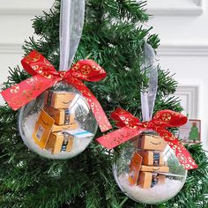 two ornaments are hanging from a christmas tree