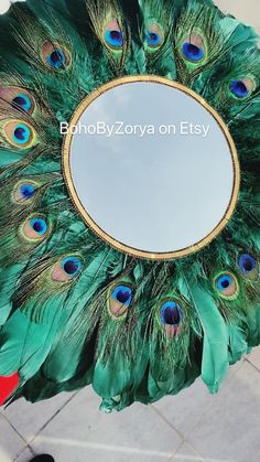 a mirror with peacock feathers sitting on top of it