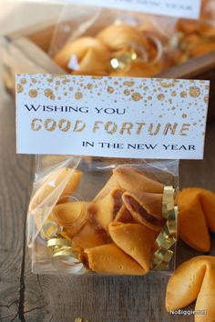 fortune cookies in a clear plastic bag on a wooden table with a card that says wishing you good fortune in the new year