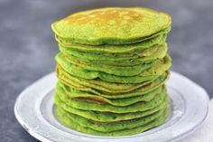 a stack of green pancakes sitting on top of a white plate