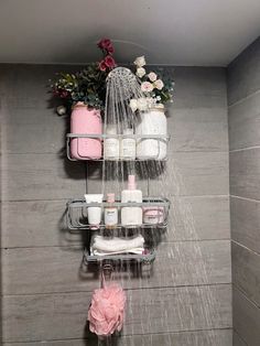 a shower head with soap and lotion in it next to a shelf filled with toiletries