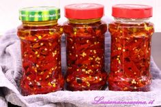 three jars filled with red and yellow confetti on top of a towel next to each other