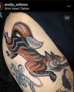 an orange and black fox tattoo on the thigh