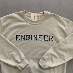 This very comfy and empowering Engineer sweatshirt is perfect for gifting to your friends and loved ones for birthdays and other celebratory events! The letters (patches) are heat pressed. Our sweatshirts run in a UNISEX fit. The sweaters naturally have a slightly oversized fit giving extra room for moving around and comfort! For this reason, we highly recommend getting your true normal size especially if you like that slight oversized fit! :) We are currently offering sizes S-L. The material is Cotton Sweatshirt With Lettering For Gift, Trendy Letter Print Sweatshirt As Gift, Casual Sweatshirt With Letter Embroidery As Gift, Crew Neck Slogan Sweatshirt As Gift, Engineer Sweatshirt, Gifts For Engineers, Engineer Graduation, Graduate Gifts, Engineer Gifts