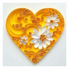 a heart shaped paper sculpture with flowers on the top and bottom, made out of quilled paper