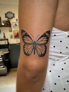 a woman's arm with a butterfly tattoo on the left side of her body