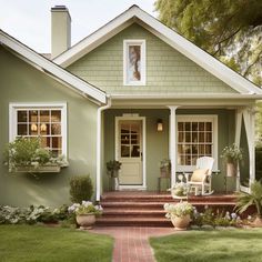 a house with green paint and white trim on the front door, steps leading up to it