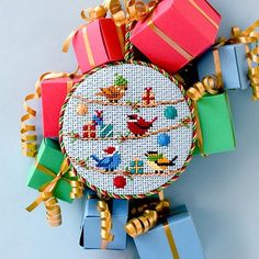 a cross stitch ornament with presents on it