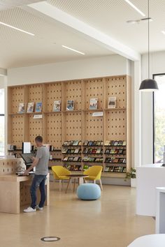 a man standing at a counter in a library