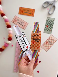 a person holding up a colorful toothbrush in front of some crafting supplies on a table