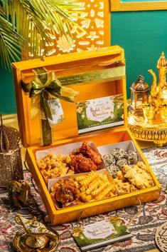 an open yellow box filled with food on top of a table next to other items