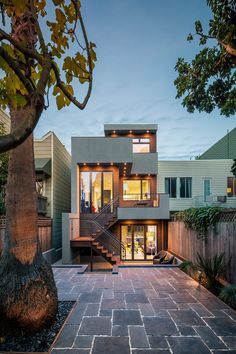 a modern house with an outdoor patio and stairs leading up to the second story area