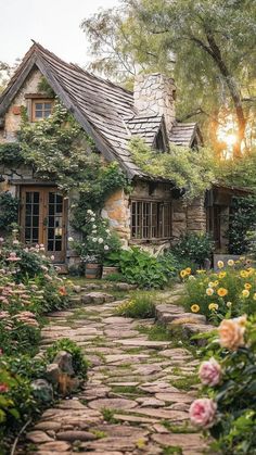 a stone path leading to a house surrounded by flowers