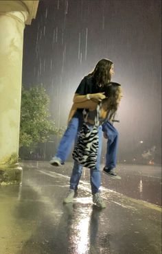 two people standing in the rain with one holding on to another person's back