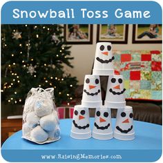 snowball toss game on a table with stuffed animals in front of it and a christmas tree