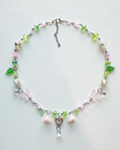 This delicate, handmade necklace features soft green, pink, and clear glass beads with flower, butterfly, and heart accents. Perfect for adding a touch of whimsy to your look. Adjustable chain for a comfortable fit. Ideal for casual wear or as a gift! Whimsical Green Necklace, Butterfly And Heart, Corpus Christi Tx, Flower Butterfly, The Fairy, Green And Pink, Handmade Necklace, Fairy Garden, Handmade Necklaces