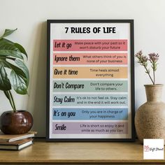 a poster with the words rules of life on it next to a potted plant