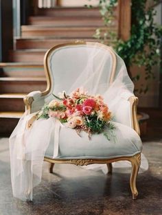 a white chair with flowers on it in front of some stairs