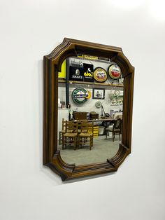 a mirror that is on the wall in front of a dining room table and chairs