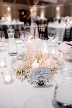 the table is set with candles, flowers and place cards for guests to write on