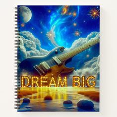 a spiral notebook with the words dream big written in front of an image of a guitar